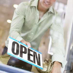 Man Putting out Open Sign